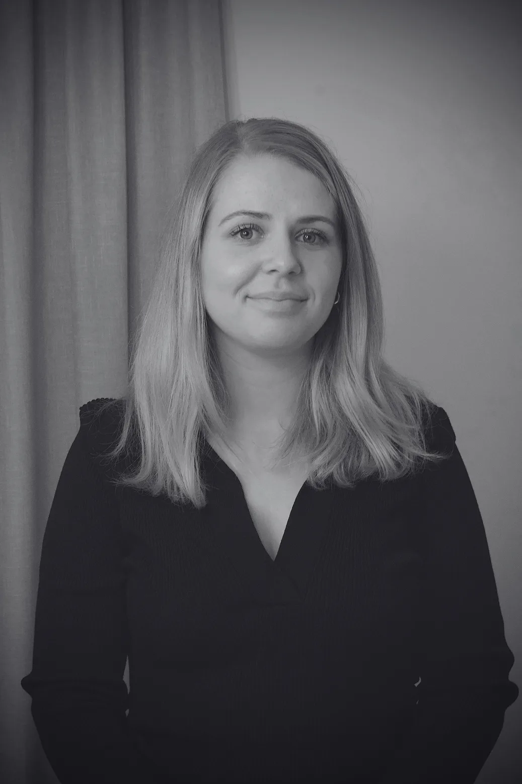 Frida Bergstrand ler mot kameran, porträtt i svartvitt